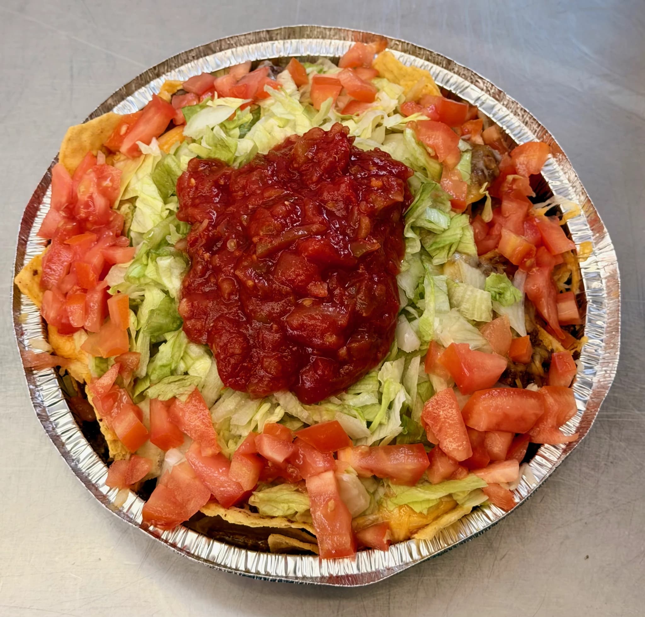 A CHUBBYS taco salad with lettuce, tomatoes, cheese, and salsa