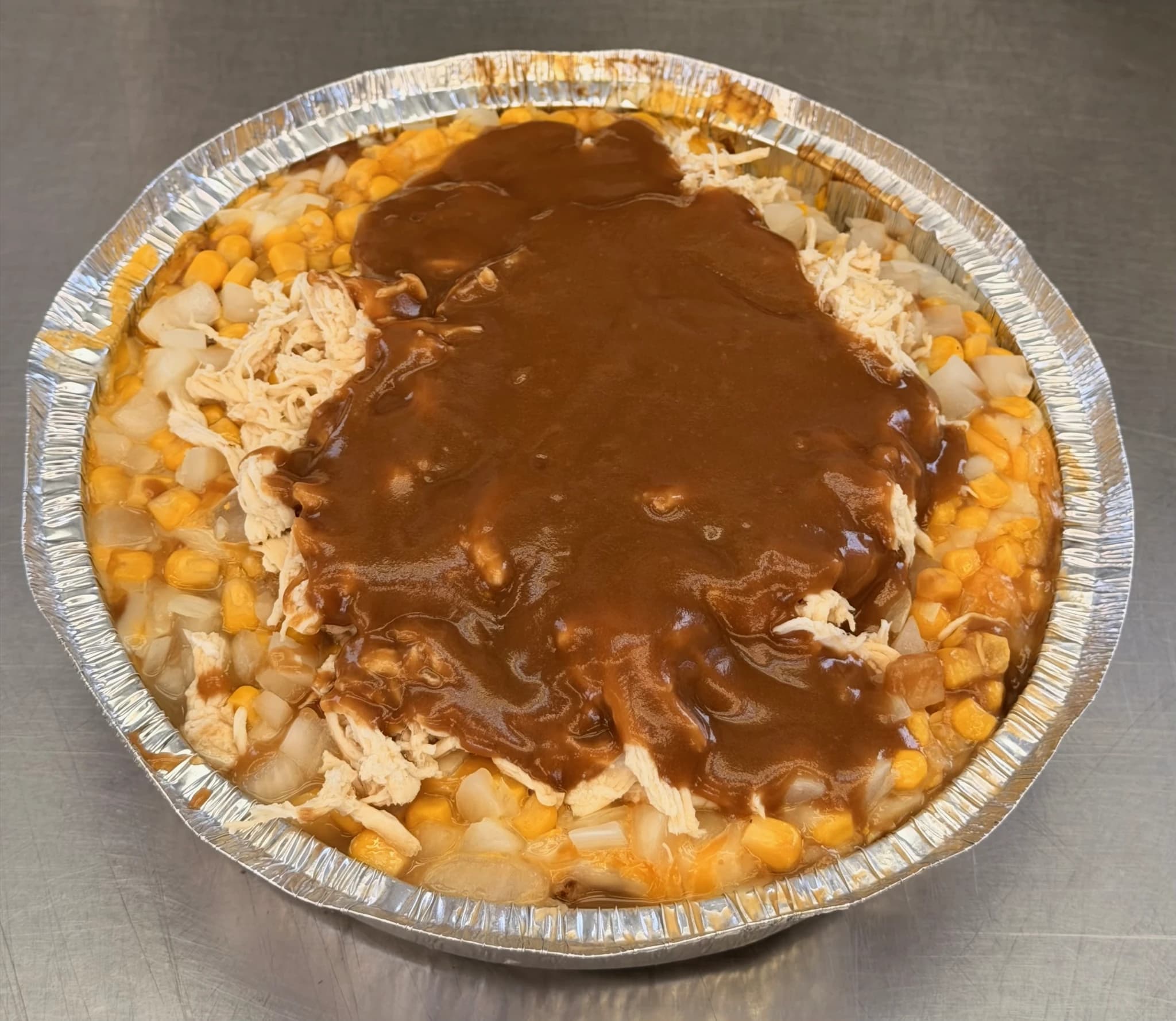 A CHUBBYS potato topped with chicken, corn, cheese, and brown gravy